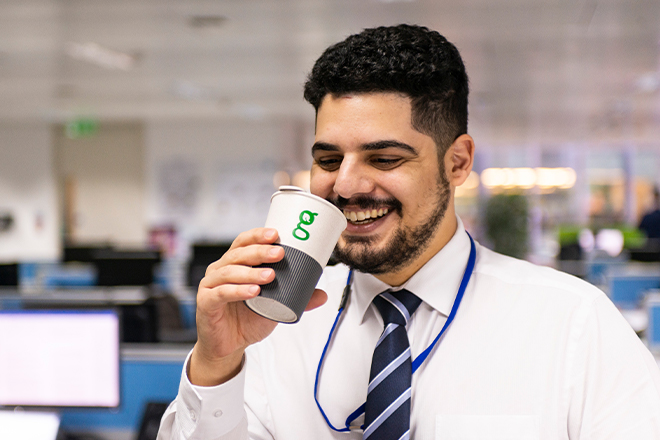 GMC employee drinking from recyclable cup