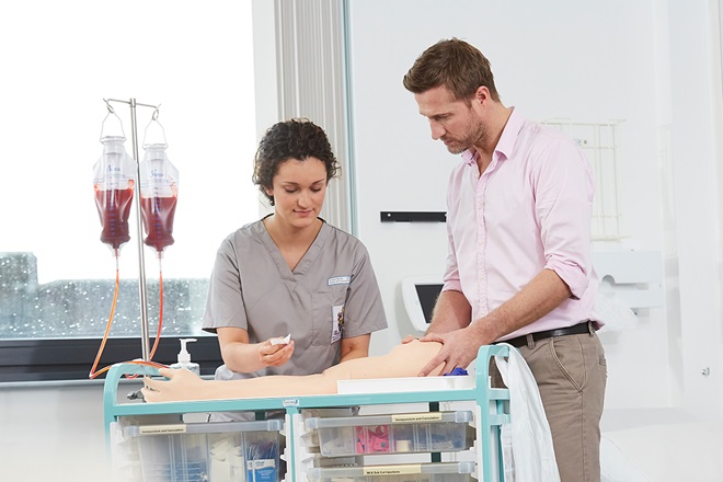 Trainer overseeing medical student