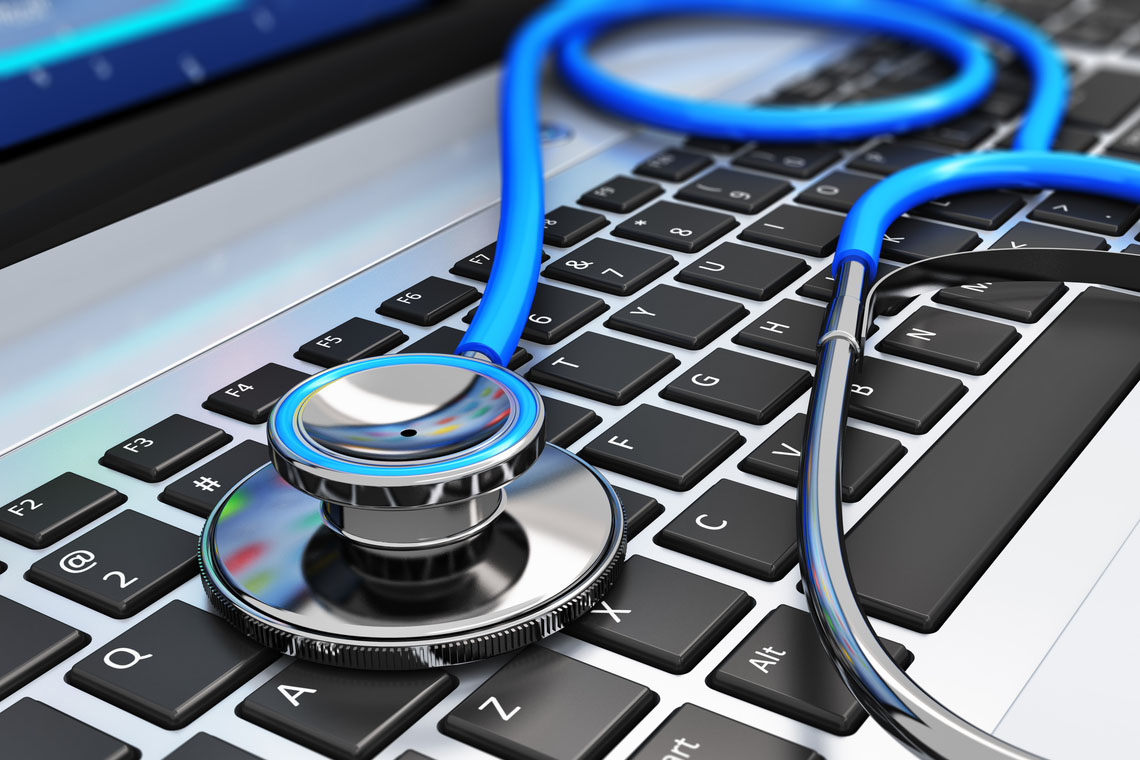 A Dr's stethoscope sitting on a laptop keyboard