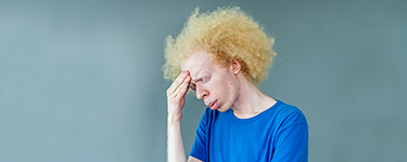 A patient holding his head in confusion