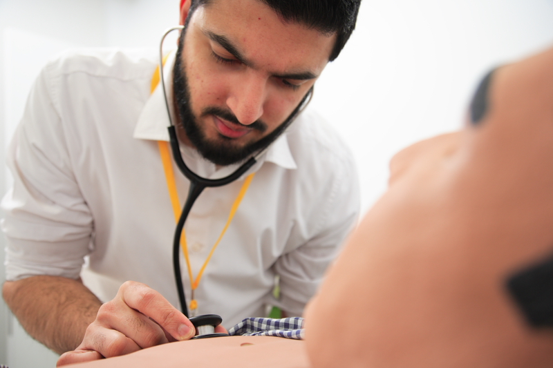 A doctor carrying out an exercise using a dummy