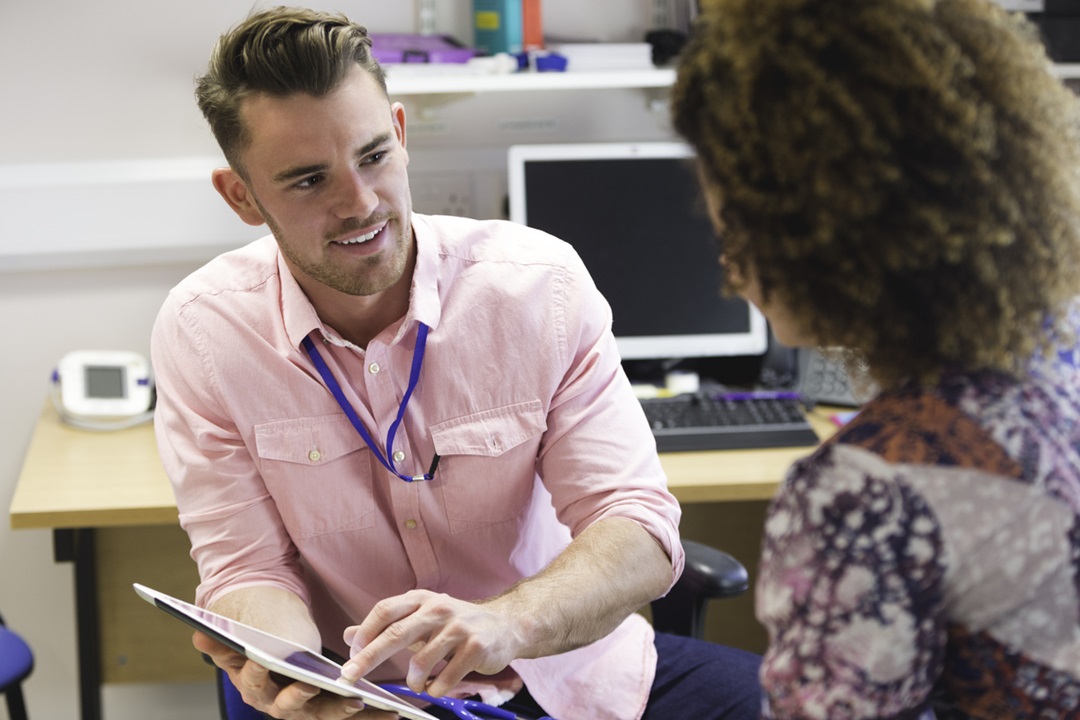 A GP sitting and talking with his patient