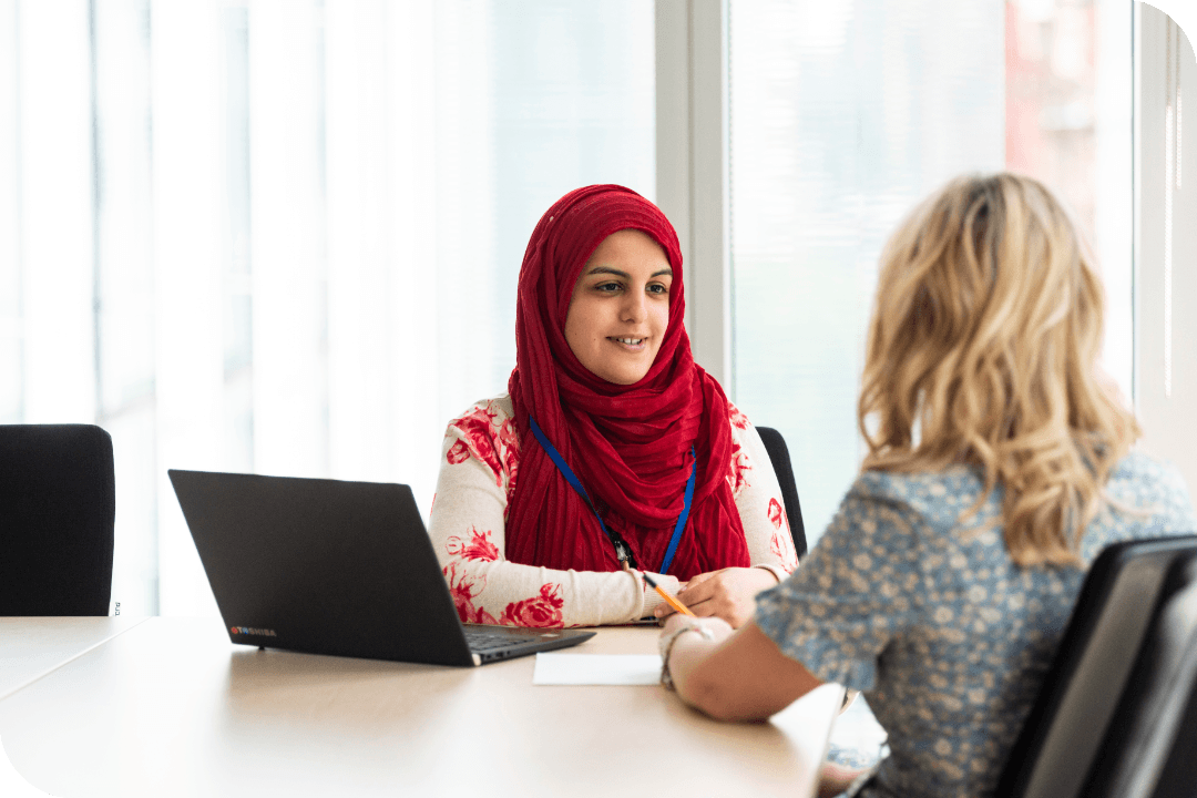 Two staff talk in a meeting room