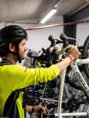A member of staff locks up their bike before work