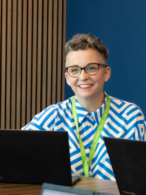 A woman smiling in front of a laptop